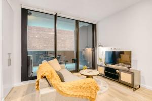 a living room with a couch and a tv at Penny Lane - 2BR Apt in the Heart of Moonee Ponds in Melbourne