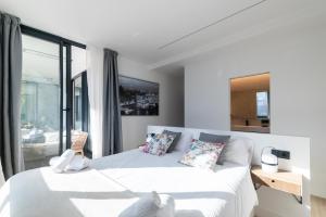 a white bedroom with a bed and a window at Riverview apartamento en LLanes in Llanes