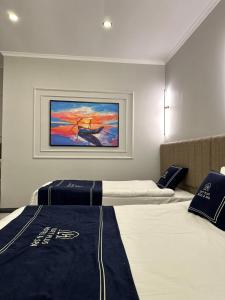 two beds in a room with a painting on the wall at Loft Park Hotel's in Arnavutköy