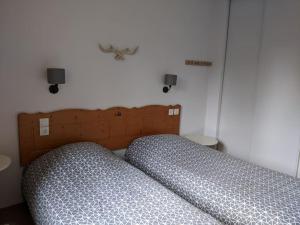 uma cama com uma cabeceira em madeira num quarto em Horizon Pelvoux Accueillant T2 pied des pistes em Puy-Saint-Vincent