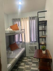 Habitación pequeña con literas y mesa. en MSG LODGING HOME, en Puerto Princesa City