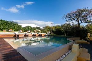 a swimming pool in a yard with chairs around it at Casa Portuguesa - Charming House in Ponta Delgada