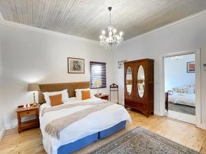 a bedroom with a large bed and a chandelier at Zuurberg Mountain Village in Addo