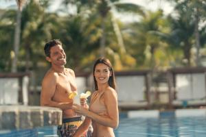 a man and a woman standing in a swimming pool at Azul Beach Resort Riviera Cancun, Gourmet All Inclusive by Karisma in Puerto Morelos
