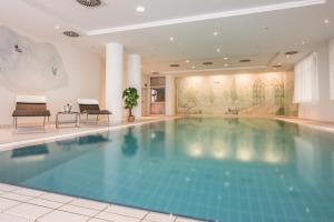 een groot zwembad in een hotellobby bij Hotel Am Moosfeld in München