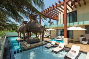 a swimming pool with chairs and a house at Azul Villa Esmeralda - Gourmet All Inclusive by Karisma in Puerto Morelos
