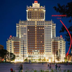 a large building with a red arrow on top of it at Céntrico Plaza España - Gran Vía II in Madrid