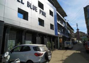 un coche blanco estacionado frente a un edificio en Hotel Blue Pine Arunachal Pradesh, en Itānagar