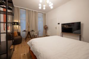 a bedroom with a bed and a table and a chair at Stylish central 1-bedroom apartment with a terrace in Vienna