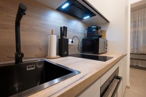 cocina con fregadero y microondas en Stylish central 1-bedroom apartment with a terrace, en Viena