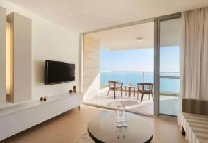 a living room with a view of the ocean at מול החוף במלון רמדה נתניה in Netanya
