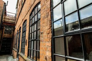 un edificio de ladrillo con ventanas negras. en VIP - 2 BR Grade 2 Luxury Industrial House with Log Burning FIRE & electric blinds in the Heart of the JQ en Birmingham