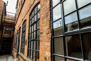 a brick building with black windows on it at VIP - 2 BR Grade 2 Luxury Industrial House with Log Burning FIRE & electric blinds in the Heart of the JQ in Birmingham