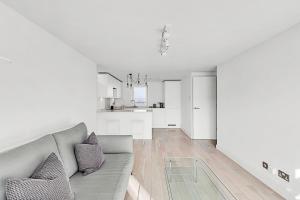 sala de estar con sofá y cocina en Radiant Chelsea Flat with City View, en Londres