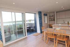 a kitchen and dining room with a table and chairs at Stylish estuary view apartment in Padstow