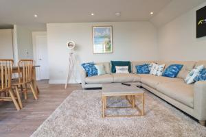 a living room with a couch and a table at Stylish estuary view apartment in Padstow