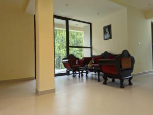 a living room with three chairs and a table at Great Residence in Avissawella