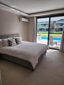 um quarto com uma cama e vista para uma piscina em Costa Vista- Standard bedroom flat#501 with private pool- kololi sands em Sere Kunda