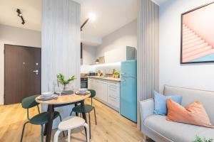 Il comprend une cuisine et un salon avec une table et un canapé. dans l'établissement SuperApart Konstruktorska 5e, à Varsovie