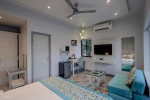 a bedroom with a bed and a living room with a couch at La Sunila Suites & Villas by WSI, Baga in Baga