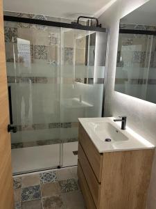 a bathroom with a sink and a glass shower at Chloe37 in Benidorm