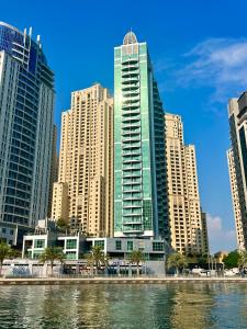 a group of tall buildings in a city next to the water at Beautiful Close to Beach Dubai Marina Apartment in Dubai