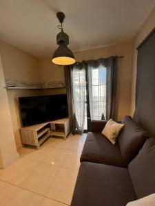 uma sala de estar com um sofá e uma televisão de ecrã plano em Villa Margherita em Playa Blanca