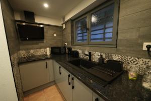 a kitchen with a sink and a tv on the wall at Pontault-Combault : Ravissante suite avec jacuzzi in Pontault-Combault