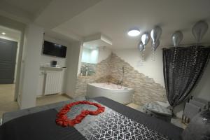 a bedroom with a bed with red flowers on it at Pontault-Combault : Ravissante suite avec jacuzzi in Pontault-Combault
