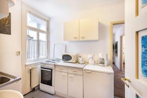 a kitchen with white cabinets and a microwave at Ferienwohnung Apfelbaum in Albstadt