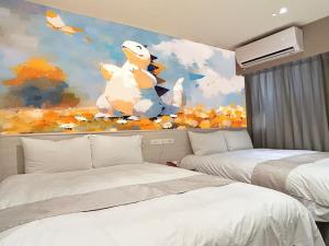 sypialnia z dwoma łóżkami i obrazem w obiekcie Dazz Inn w mieście Taizhong