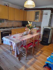 een keuken met een tafel met een vaas met bloemen erop bij Appartamento Val Visdente 2 in Santo Stefano di Cadore