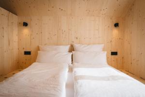 two beds in a room with wooden walls at Lovt am See 
