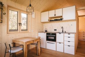 cocina con armarios blancos y mesa de madera en Lovt am See 