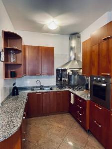 ヴェローナにあるL'appartamento di Giuliettaのキッチン(木製キャビネット、コンロ付)