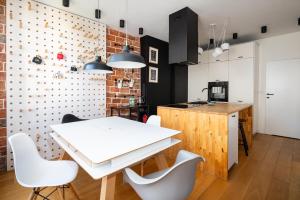 uma cozinha e sala de jantar com uma mesa branca e cadeiras em Ochota Siewierska Modern Apartment em Varsóvia