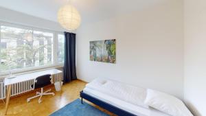 una camera con letto, scrivania e finestra di Unique Serviced Living @ Gellert, Aeschenplatz (0141) a Basilea