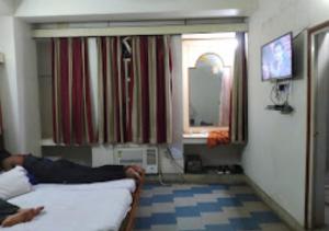 a person laying on a bed in a room at Hotel Chanderlok Odisha in Rourkela