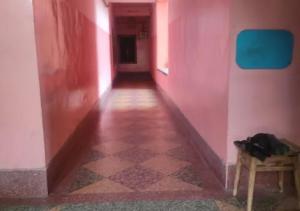 an empty hallway with a pink wall and a table at Hotel Chanderlok Odisha in Rourkela