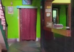 uma parede verde com uma porta vermelha num quarto em Hotel Chanderlok Odisha em Rourkela