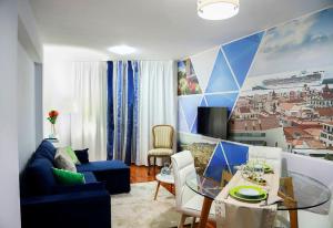uma sala de estar com um sofá azul e uma mesa em Funchal downtown 5min Marina + 2 bedroom + parking no Funchal