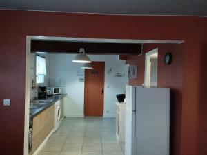 カイユー・シュル・メールにあるLe Bol d'Airの赤い壁のキッチン(白い冷蔵庫付)