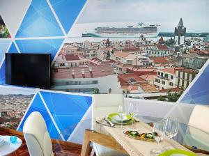 a table with wine glasses and a view of a city at Funchal downtown 5min Marina + 2 bedroom + parking in Funchal