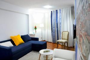 uma sala de estar com um sofá azul e uma cadeira em Funchal downtown 5min Marina + 2 bedroom + parking no Funchal
