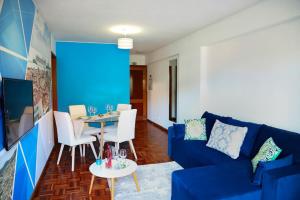 uma sala de estar com um sofá azul e uma mesa em Funchal downtown 5min Marina + 2 bedroom + parking no Funchal