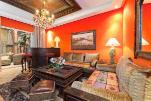 Art Palace Suites & Spa في الدار البيضاء: غرفة معيشة مع جدران برتقالية وأريكة وطاولة