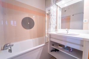 y baño con lavabo, bañera y espejo. en Sfl 1 appt 4-6 couchages, en Saint-François-Longchamp