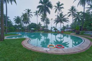 a swimming pool with two orange tubes in the grass at The Raviz Kadavu, Kozhikode in Kozhikode