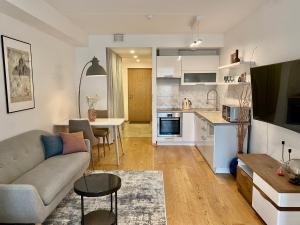 a living room and kitchen with a couch and a table at Cozy Home Apartment - Tallinn City Center in Tallinn