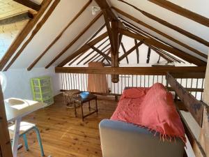 a attic room with a couch and a chair at Moura in Labastide-Villefranche